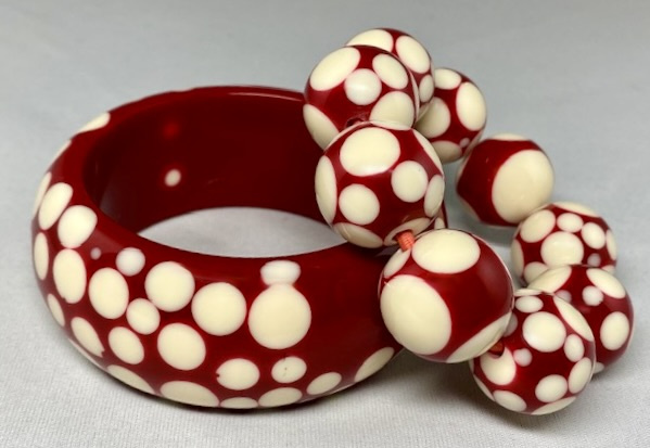 Retired Sobral dark red with cream dots resin bangle measures 1 3/8" wide X 2 9/16" wrist opening X 