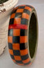 AB153 H Kronimus orange/black on grey checkerboard bakelite bangle